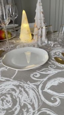 Klasik beyaz sofra takımı, gözlük ve altın jantlı kadehlerle Noel sofrası. İtalyan seramik sofra takımı. Estetik ve yaşam tarzı. İç dizayn. Yüksek kalite 4k görüntü