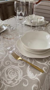 Klasik beyaz sofra takımı, gözlük ve altın jantlı kadehlerle Noel sofrası. İtalyan seramik sofra takımı. Estetik ve yaşam tarzı. İç dizayn. Yüksek kalite 4k görüntü