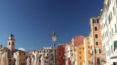 Eski kasabadaki geleneksel eski binalar, Camogli. Parlak renkli evler ve İtalya 'nın balıkçı köyünün çatıları. Gökteki martılar. Tasarım için arka plan. - Evet. Yüksek kalite 4k görüntü