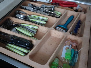 Mutfaktaki ahşap rafta çatal bıçak takımı. Depo, organizasyon. Temiz dolaplar ve raflar. Bıçaklar, kaşıklar ve çatallar, günlük kullanım için küçük eşyalar. Yüksek kalite fotoğraf