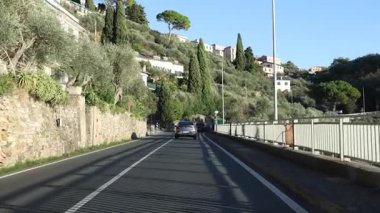 Dağ yolu, doğa, zeytin ağaçları ve İtalya 'nın Liguria sahilindeki taş duvar. Güneşli sonbahar gününde ulaşım ve yollar. Yüksek kalite 4k görüntü