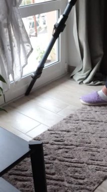 Anonim kişi, modern, yüksek teknoloji kablosuz dik elektrikli süpürge kullanarak tozları evden kaldırıyor. Temizlik ve sağlık. İç dizayn ve ekipman, elektrikli aletler. Yüksek kalite 4k görüntü