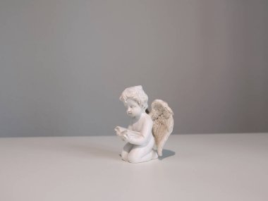 Tasarım için beyaz arka planda beyaz seramik melek figürü. İnanç, semboller ve gelenekler. Yüksek kalite fotoğraf