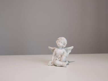 Tasarım için beyaz arka planda beyaz seramik melek figürü. İnanç, semboller ve gelenekler. Yüksek kalite fotoğraf