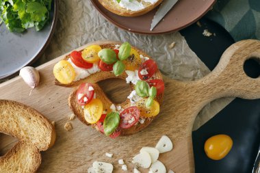 Kırmızı ve sarı kiraz domatesli yuvarlak bruschetta ve meşe ağacından yapılmış keçi peyniri. Çiftlik ürünü, kabuklu ekmek. Yemek ve sağlıklı beslenme. Yüksek kalite fotoğraf