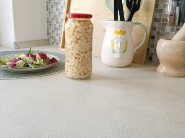 Mutfakta kavanozda beyaz fasulye pişirdim. Tabakta yeşil salata. Yüksek kalitede çiftlik yapımı ev yapımı malzemeler. Sağlıklı beslenme. Geleneksel İtalyan mutfağı. Yüksek kalite fotoğraf
