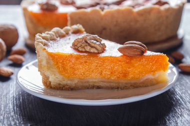 Siyah ahşap arka planda geleneksel Amerikan balkabağı turtası dilimi. Kapat..