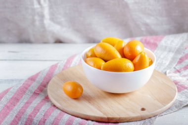 Tahta bir mutfak tahtasındaki beyaz tabakta kumkatlar. Yaklaş..