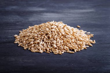 Siyah arka planda izole edilmiş bir yığın yulaf tanesi. Kapat, seçici odak, kenar görünüm.