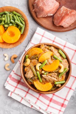 Kızarmış domuz, şeftali, fındık ve yeşil fasulye. Üst manzara, yakın çekim, düz yatak, Çin mutfağı. keten tekstil.