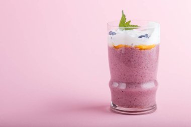 Pembe pastel arka planda hanımeli, keten ve chia 'lı smoothie. Yan görünüm, kapat, boşluğu kopyala.