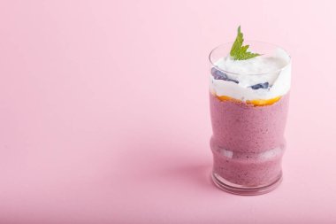 Pembe pastel arka planda hanımeli, keten ve chia 'lı smoothie. Yan görünüm, kapat, boşluğu kopyala.