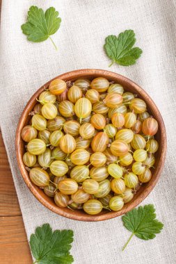 Ahşap arka planda ahşap kasede taze yeşil bektaşi üzümü. Üst görünüm, düz görünüm, yakın çekim.