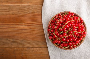 Ahşap arka planda ahşap kasede taze kırmızı frenk üzümü. Üst görünüm, düz görünüm, kopyalama alanı.