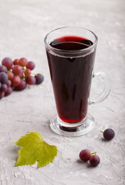 Gri bir arka planda bir bardak kırmızı üzüm suyu. Morninig, bahar, sağlıklı içki konsepti. Yan görünüm, kapat.