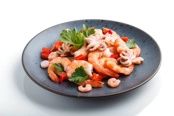 Kaynamış karides, karides ve beyaz arka planda izole edilmiş mavi seramik tabakta otlu küçük ahtapotlar. Yan görünüm, kapat.