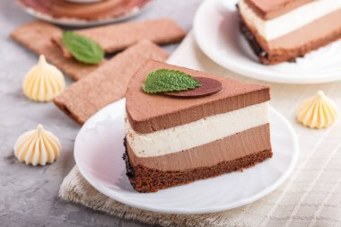 Sütlü, sufle sütlü, gri arka planda kahve ve keten peçeteli kek. Yan görünüm, yakın görünüm, seçici odak.