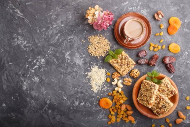 Yulaf gevreği, hurma, kurutulmuş kayısı, kuru üzüm, fındık ve bir fincan fındık. Üst görünüm, düz görünüm, kopyalama alanı.