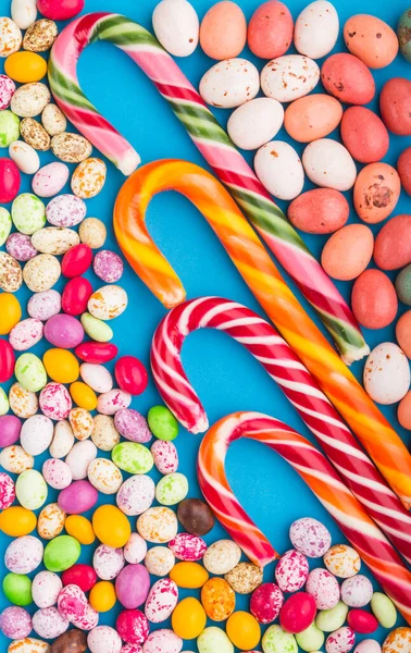 Mavi Arka Planda Renkli Renkli Şekerler Noel Bastonu Çikolata Yumurtası — Stok fotoğraf