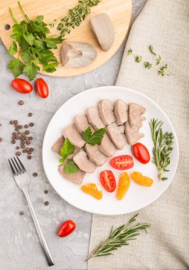 Kaynamış domuz dili, domatesli ve gri beton arka planda otlu ve keten tekstil. Üst manzara, kapat, düz yat..