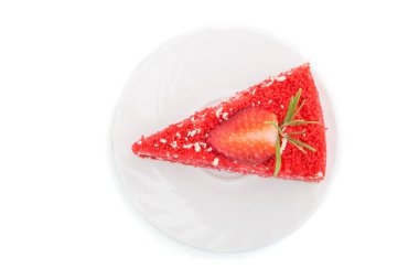 Beyaz arka planda süt kremalı ve çilekli ev yapımı kırmızı kadife kek. Üst görünüm, kapat.