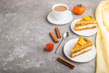 Hurma ve balkabaklı ev yapımı kek ve gri beton arka planda sarı tekstil ile bir fincan kahve. Yan görünüm, boşluğu kopyala, kapat.