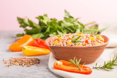 Kil kasede sebzeli karabuğday lapası gri beton arka plan ve keten tekstil. Yan görüş, seçici odaklanma, yakın çekim. Rus geleneksel mutfağı.