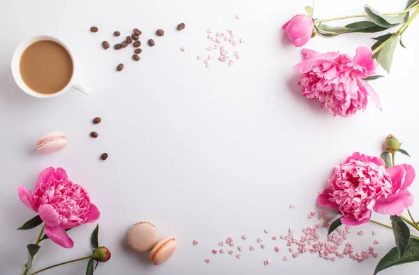 Pembe şakayık çiçekleri ve beyaz arka planda bir fincan kahve. Morninig, bahar, moda kompozisyonu. Düz konum, üst görünüm, kopyalama alanı.