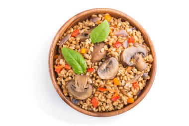 Beyaz arka planda izole edilmiş ahşap kasede sebze ve mantarlı yulaf lapası. Üst manzara, düz yatak, yakın çekim. Rus geleneksel mutfağı.