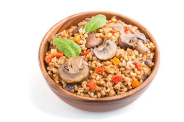 Beyaz arka planda izole edilmiş ahşap kasede sebze ve mantarlı yulaf lapası. Yan görüş, yakın çekim. Rus geleneksel mutfağı.