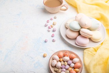 Renkli zephyr veya bir fincan kahveli marşmelov ve beyaz beton arka plan ve sarı tekstil üzerine sürükleyici. Yan görünüm, boşluk kopyala.