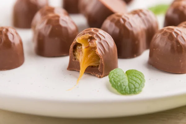 Caramelle Cioccolato Con Mandorle Caramello Fondo Bianco Legno Tessuto Verde — Foto Stock
