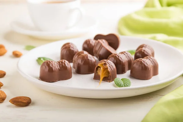 Caramelle Cioccolato Con Mandorle Caramello Fondo Bianco Legno Tessuto Verde — Foto Stock