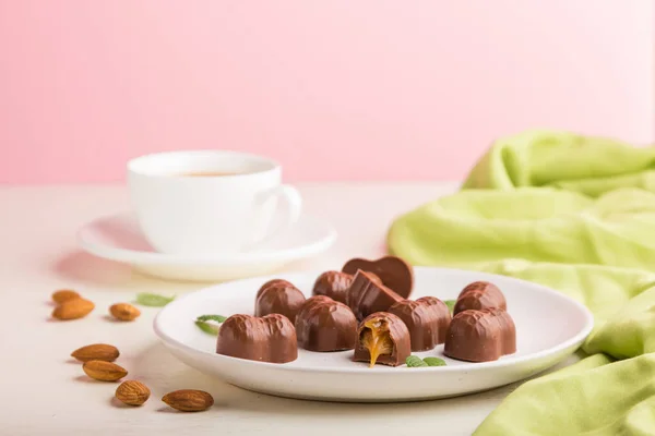 Caramelle Cioccolato Caramello Con Mandorle Una Tazza Caffè Uno Sfondo — Foto Stock