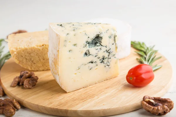 蓝色奶酪和各种奶酪与迷迭香和西红柿在木板上的白色木制背景 选择性聚焦 — 图库照片