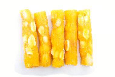 Beyaz arka planda izole edilmiş yer fıstıkları ile geleneksel sarı Türk lokumu (Raf lokum). Üst görünüm, düz görünüm, yakın çekim.