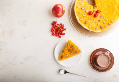 Geleneksel Amerikan balkabağı turtası. Beyaz ahşap arka planda Hawthorn kırmızı böğürtlenleri ve kabak tohumlarıyla süslenmiş. Üst görünüm, düz görünüm, kopyalama alanı.