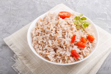 Cilalanmamış pirinç lapası haşlanmış sebzeler ve gri beton arka planda keklik otu ve keten tekstil. Yan görünüm, kapat.