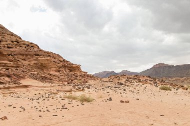 Çöl, kızıl dağlar, kayalar ve bulutlu gökyüzü. Mısır, renk kanyonu, Sina Yarımadası, Dahab.