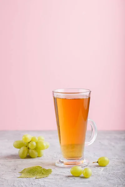 一杯绿色葡萄汁 背景是灰色和粉色的 健康的饮料概念 侧视图 复制空间 — 图库照片