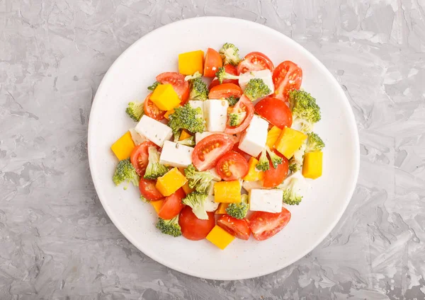 蔬菜沙拉 配以西兰花 西红柿 菲塔芝士和南瓜 白色陶瓷盘 灰色混凝土背景 顶视图 — 图库照片