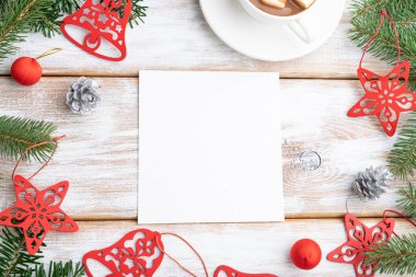 Noel veya Yeni Yıl kompozisyonu, şablon. Süslemeler, kırmızı yıldızlar, çanlar, koniler, köknar ve ladin dalları, bir fincan kahve, beyaz ahşap arka planda. Üst görünüm, kopyalama alanı, düz uzanma.