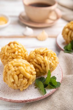 Geleneksel Tatar şekeri hamur ve baldan yapılmış beyaz ahşap arka planda bir fincan kahve ve keten tekstil. Yan görünüm, yakın görünüm, seçici odak.