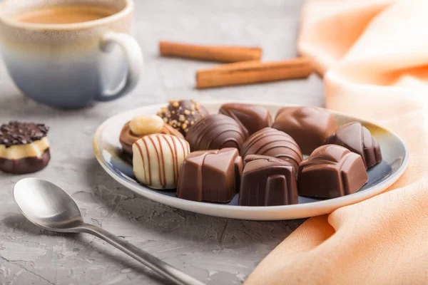 Diverse Caramelle Cioccolato Una Tazza Caffè Sfondo Grigio Cemento Tessuto — Foto Stock