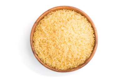 Beyaz arka planda çiğ altın pirinçli ahşap kase. Üst görünüm, kapat.