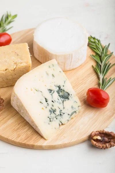 蓝色奶酪和各种奶酪与迷迭香和西红柿在木板上的白色木制背景 选择性聚焦 — 图库照片