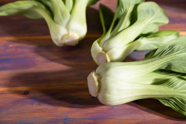 Taze yeşil bok choy ya da renkli ahşap arka planda Çin lahanası. Sert ışık, kontrast. Yan görünüm, yakın görünüm, seçici odak.