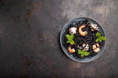 Karides, karides ve küçük ahtapotlu siyah mürekkep balığı makarnası. Üst görünüm, düz görünüm, kopyalama alanı.