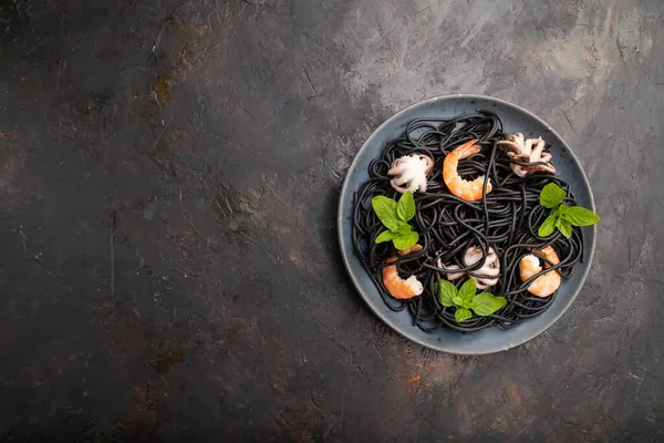 Karides, karides ve küçük ahtapotlu siyah mürekkep balığı makarnası. Üst görünüm, düz görünüm, kopyalama alanı.