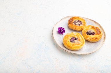 Reçelli küçük peynirli kekler ve beyaz beton arka planda bir fincan kahveyle badem. Yan görünüm, kopyala boşluk, kapat.